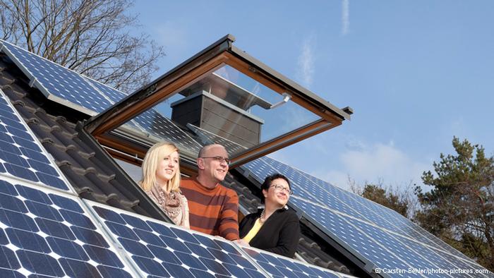 Một gia đình và các tấm pin mặt trời trên mái nhà (ảnh: Carsten Behler / photon pictures.com)